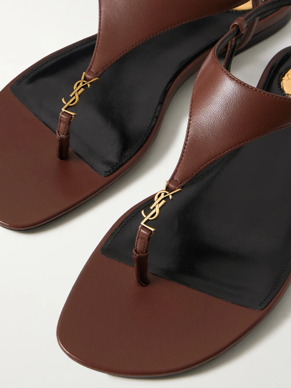 Close-up detail of the Saint Laurent Cassandra Embellished Leather Slingback Sandals