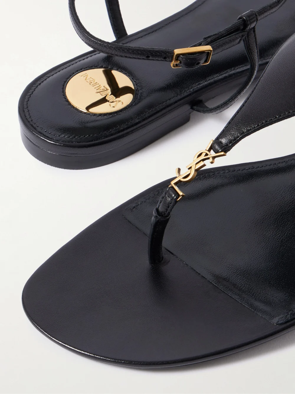 Close-up detail of the Saint Laurent Cassandre Embellished Leather Slingback Sandals