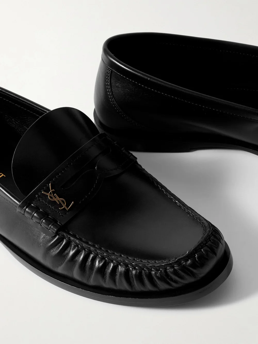 Close-up detail of the Saint Laurent Laurent Cassandre-embellished Glossed-leather Loafers