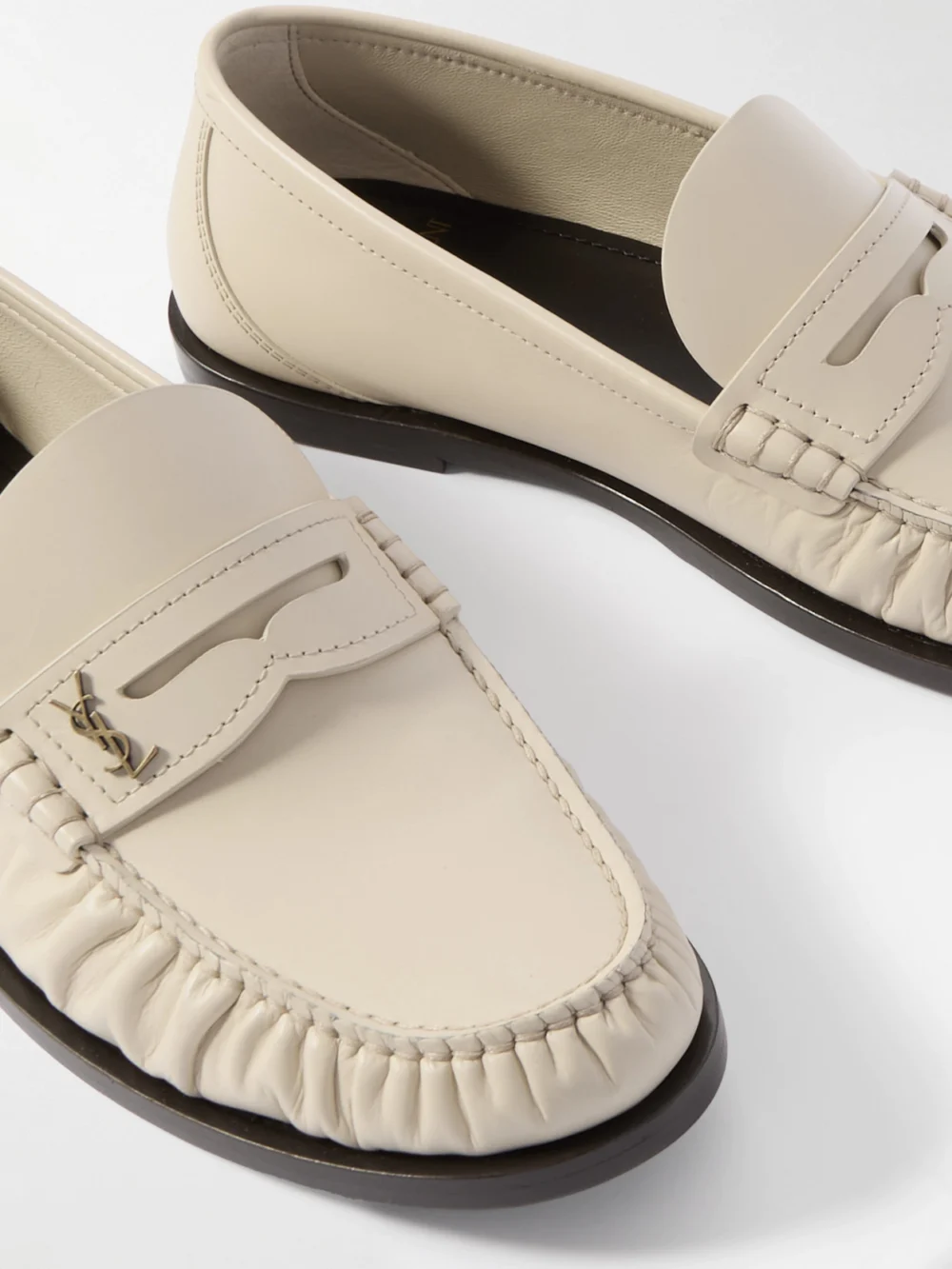 Close-up detail of the Saint Laurent Laurent Cassandre-embellished Glossed-leather Loafers