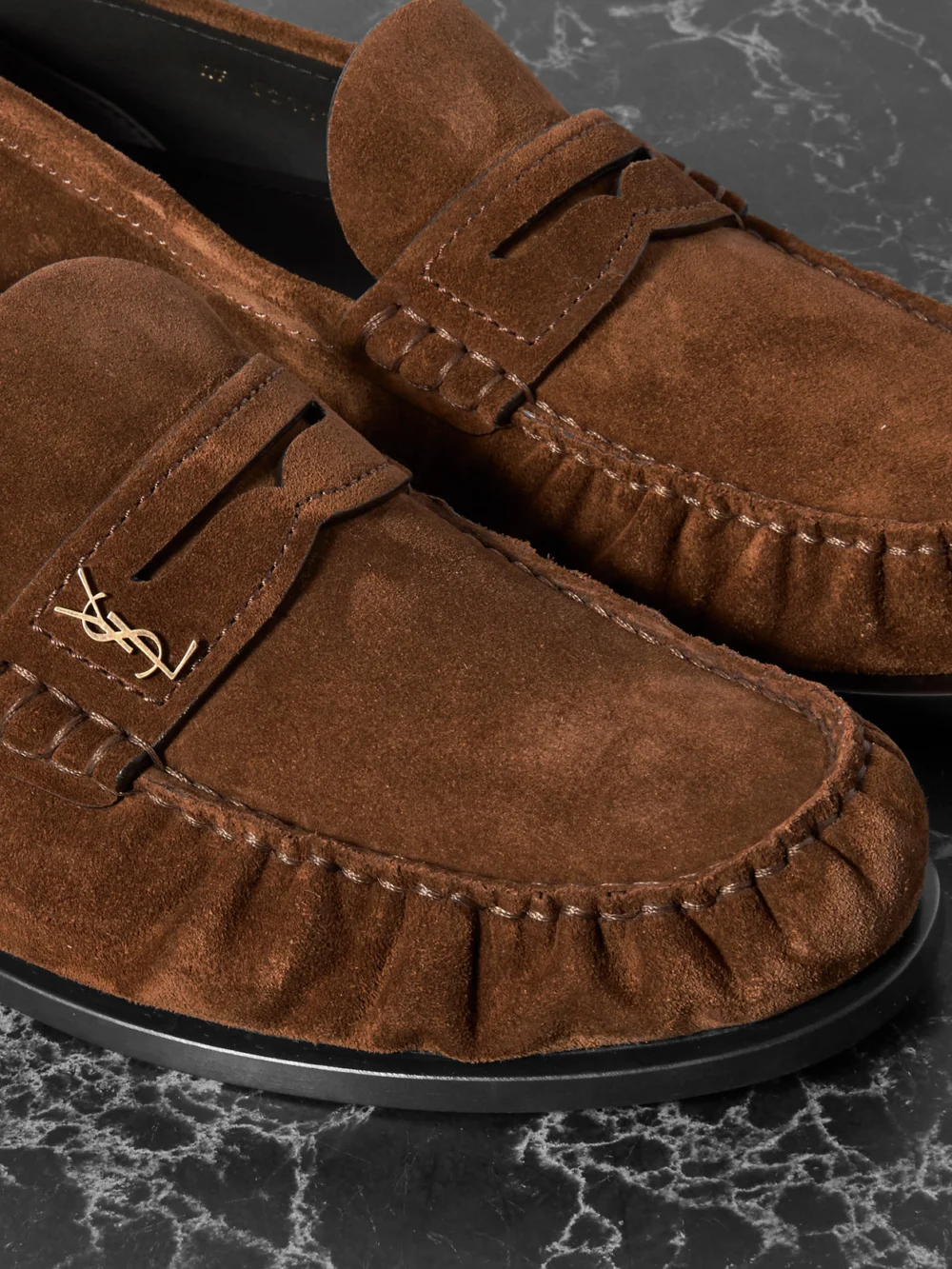 Close-up detail of the Saint Laurent Laurent Cassandre-embellished Suede Penny Loafers