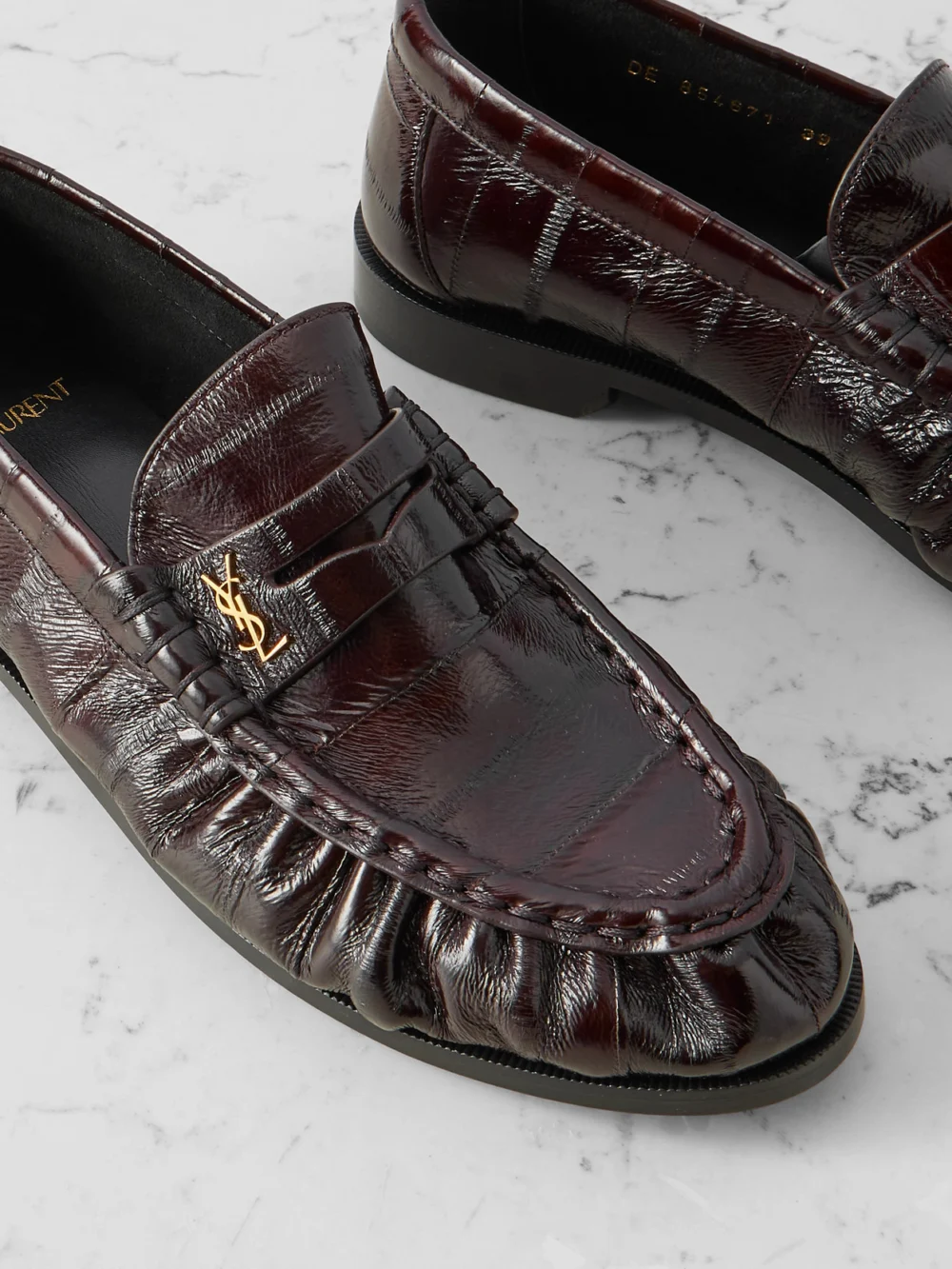 Close-up detail of the Saint Laurent Le Loafer Cassandre-embellished Eel Loafers
