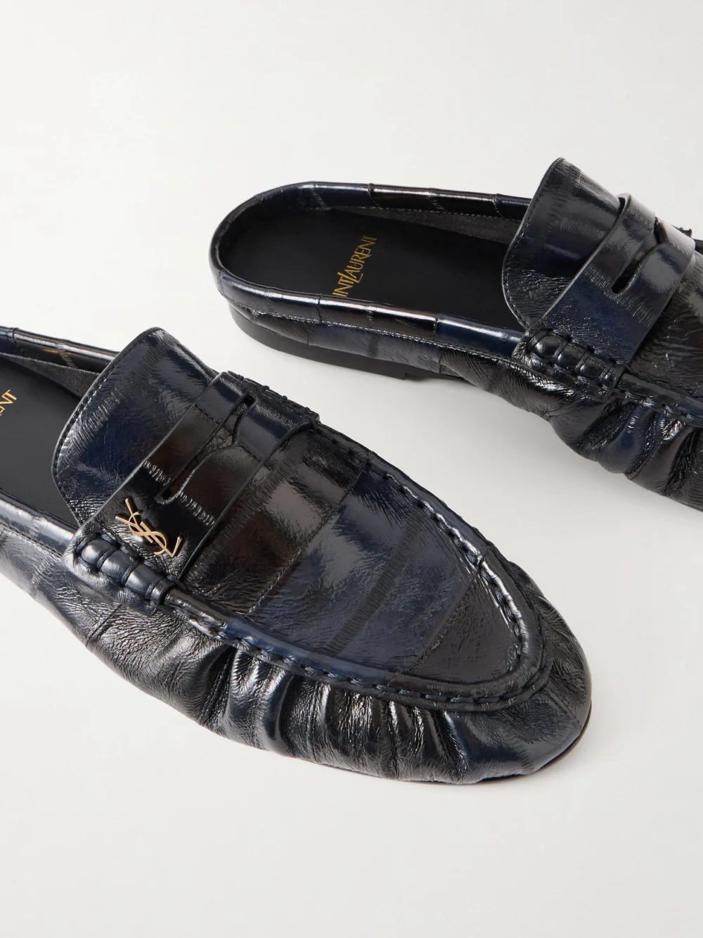 Close-up detail of the Saint Laurent Le Loafer Cassandre-embellished Eel Mules