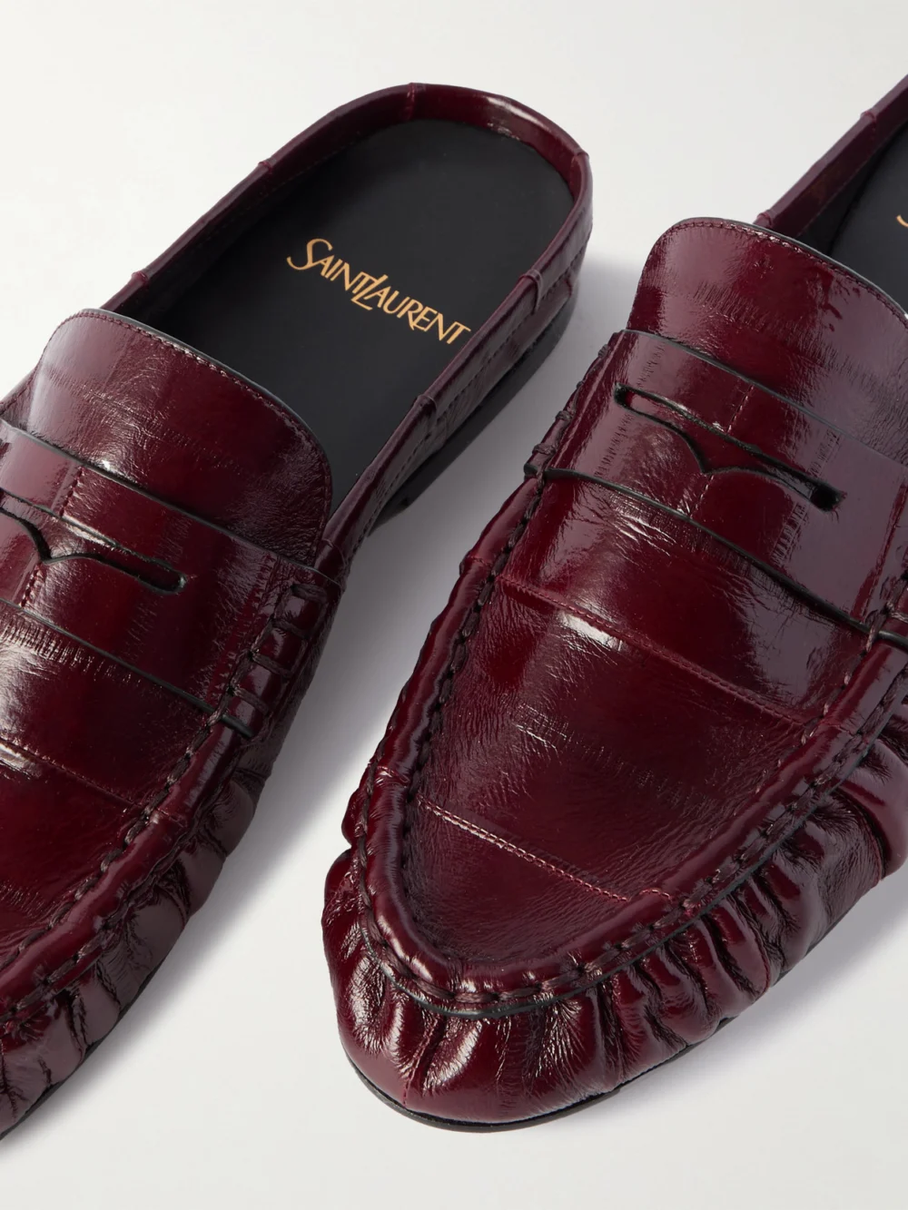 Close-up detail of the Saint Laurent Le Loafer Cassandre-embellished Eel Mules