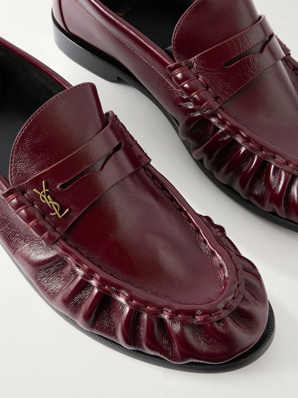 Close-up detail of the Saint Laurent Le Loafer Cassandre-embellished Glossed-leather Loafers