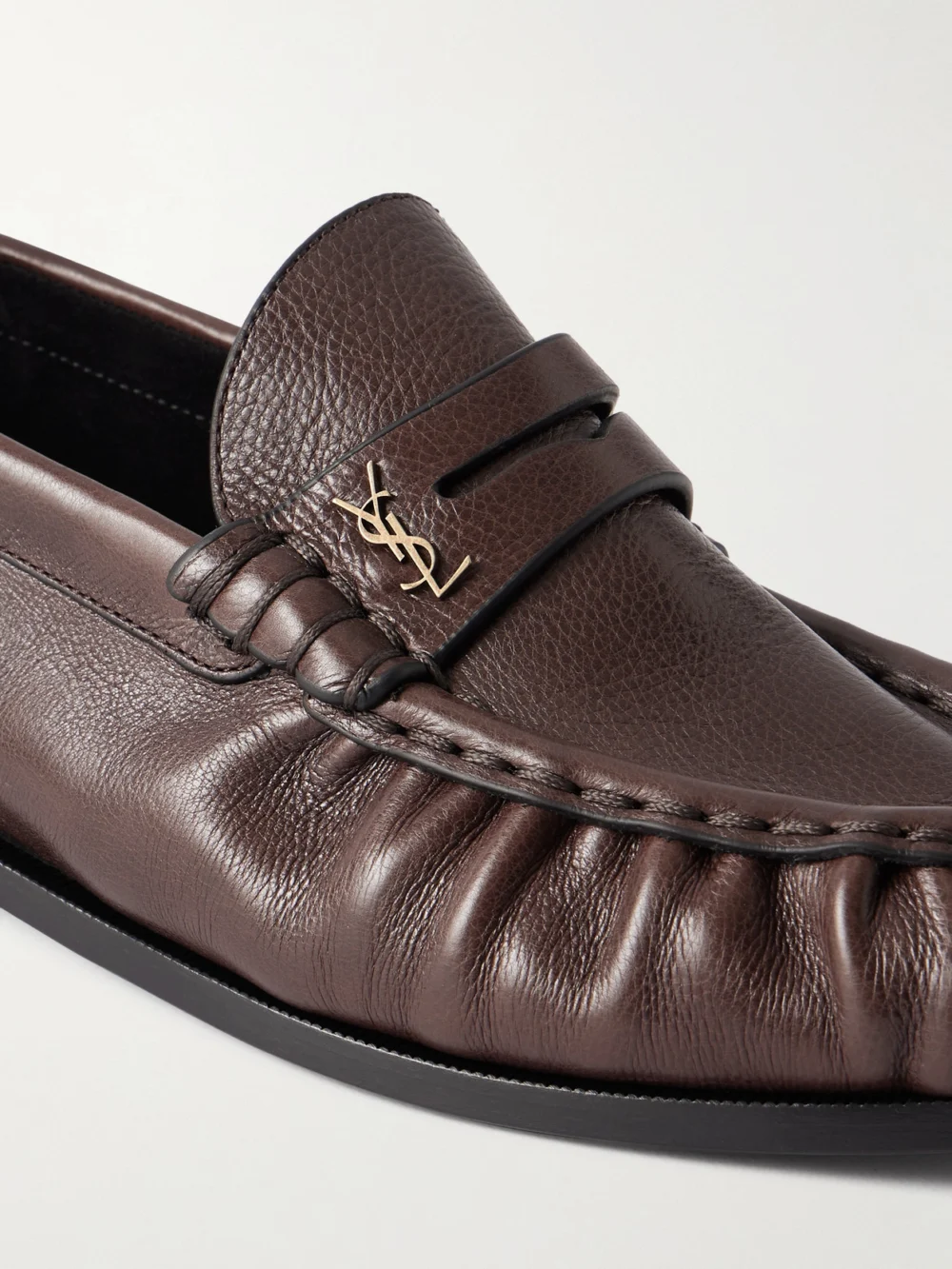Close-up detail of the Saint Laurent Le Loafer Cassandre-embellished Textured-leather Loafers