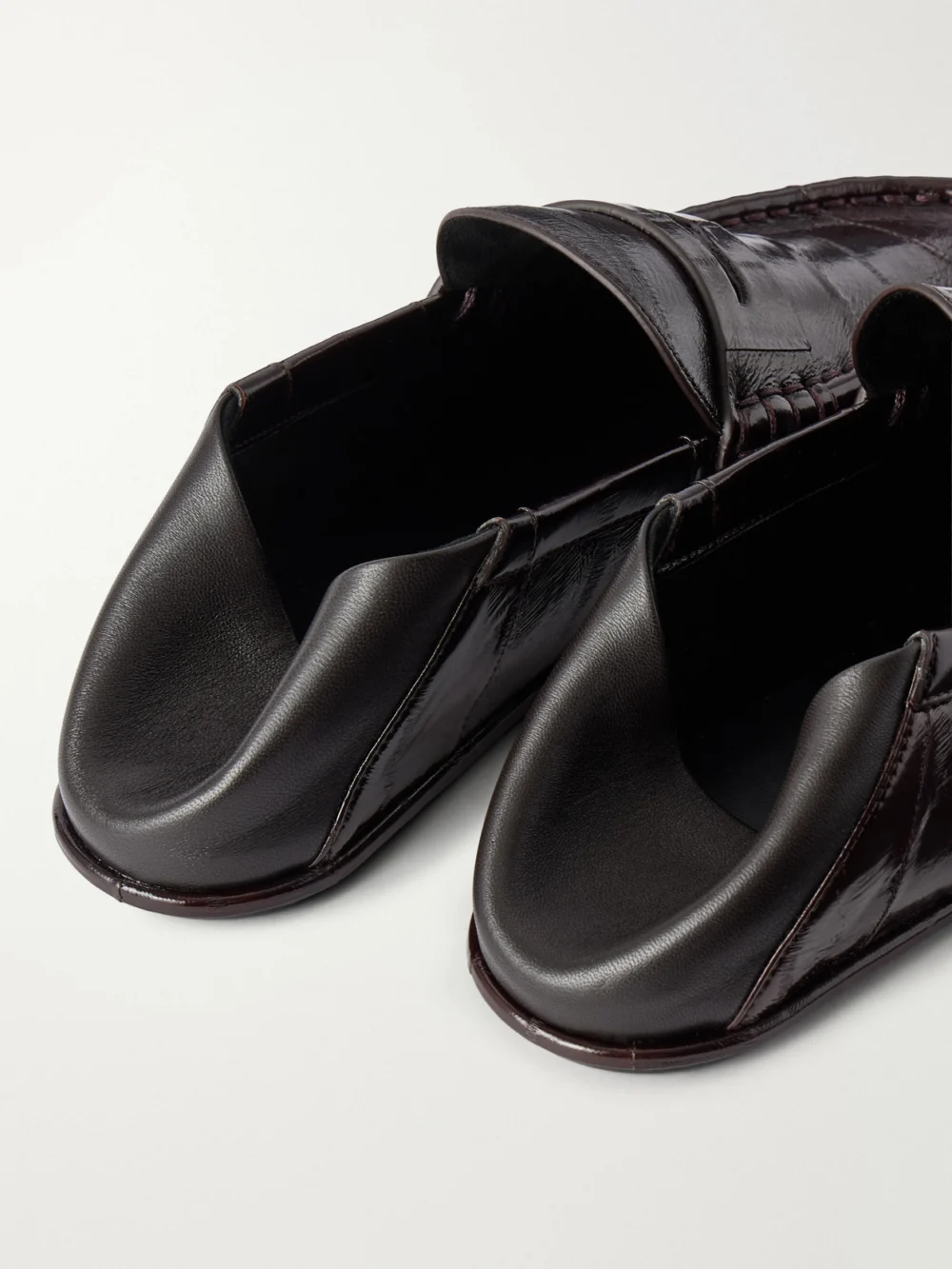 Close-up detail of the Saint Laurent Le Loafers Cassandra-embellished Collapsible-heel Leather-trimmed Eel Loafers
