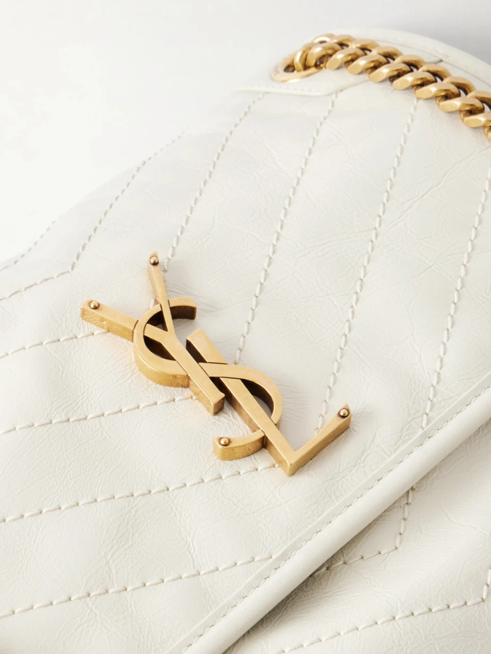Close-up detail of the Saint Laurent Niki Cassandre-embellished Crinkled-leather Shoulder Bag