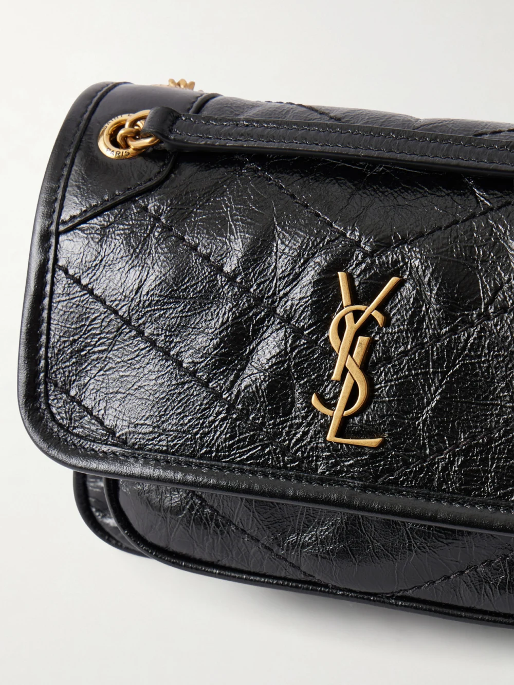 Close-up detail of the Saint Laurent Niki Mini Cassandre-embellished Crinkled-leather Mini Bag