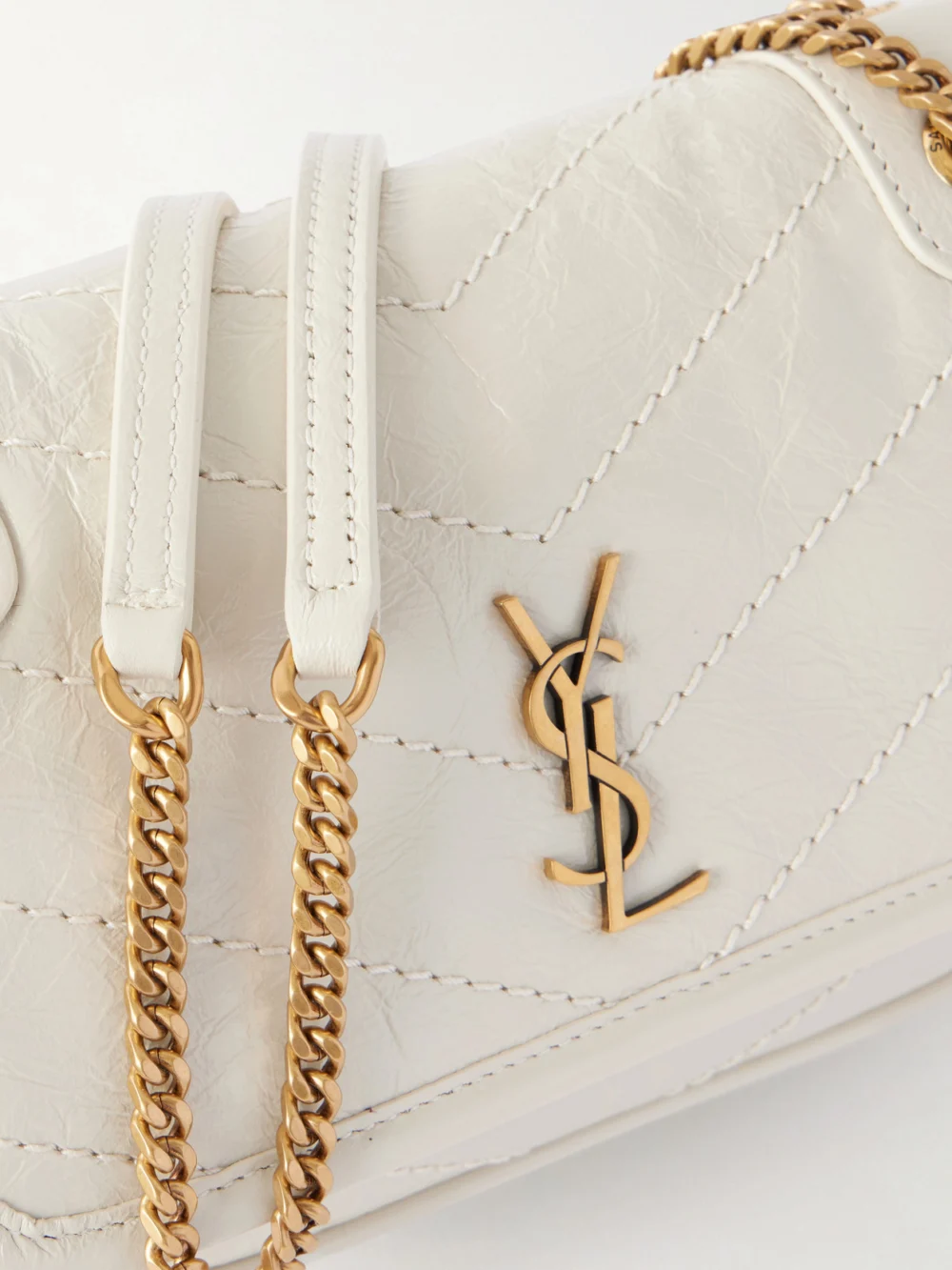 Close-up detail of the Saint Laurent Niki Mini Cassandre-embellished Crinkled-leather Shoulder Bag