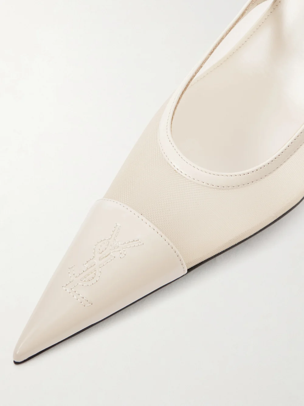 Close-up detail of the Saint Laurent Renée Cassandre-embroidered Patent Leather-trimmed Mesh Slingback Pumps