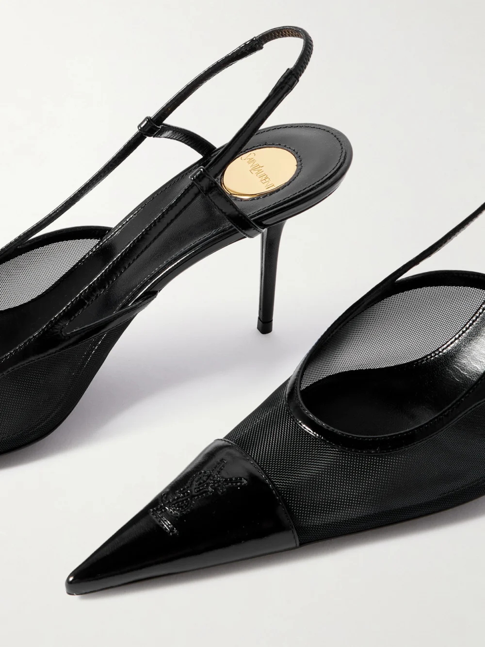 Close-up detail of the Saint Laurent Renée Cassandre-embroidered Patent Leather-trimmed Mesh Slingback Pumps