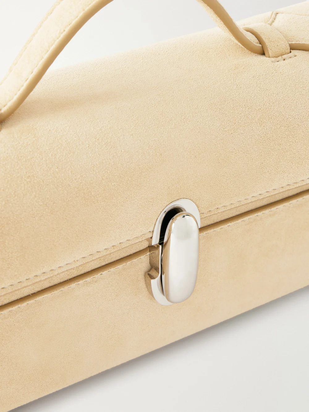 Close-up detail of the Savette Slim Symmetry Pochette Suede Top-handle Bag