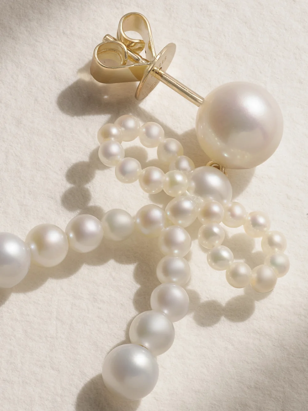 Close-up detail of the Sophie Bille Brahe Bow 14-karat Recycled Gold Pearl Earrings