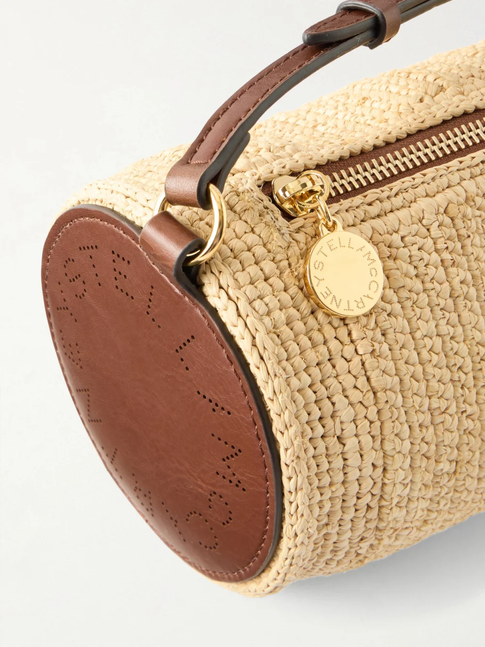 Close-up detail of the Stella McCartney Barrel Vegetarian Material-trimmed Raffia Shoulder Bag