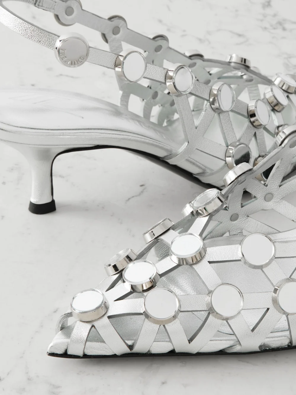 Close-up detail of The Attico Grid Studded Metallic Leather Slingback Pumps