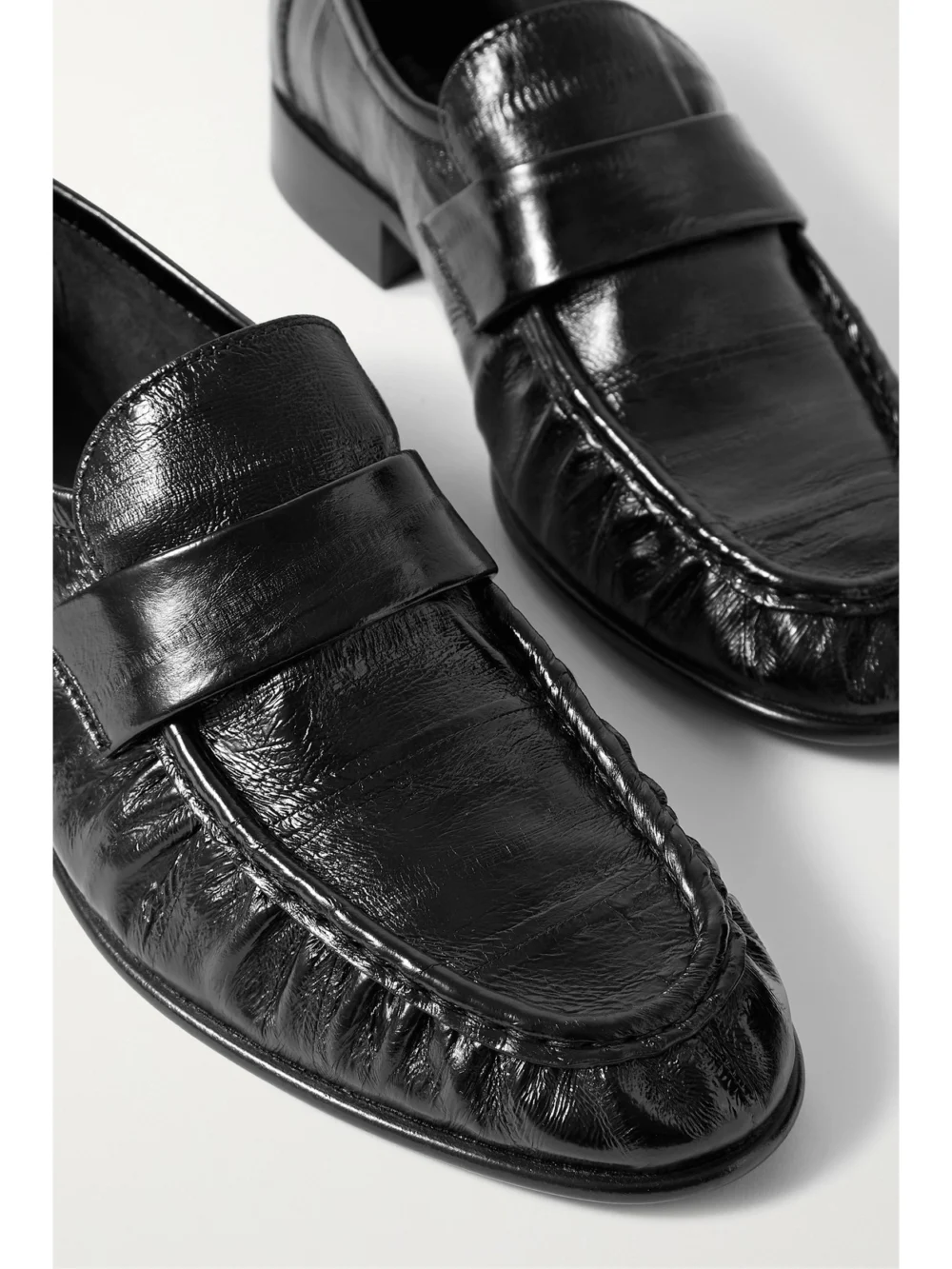 Close-up detail of The Row Soft Paneled Glossed-eel Loafers