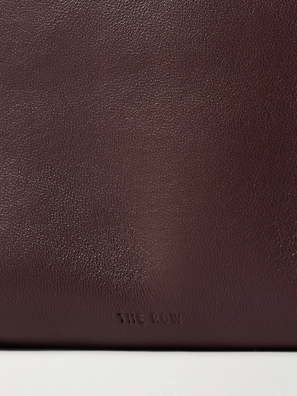 Close-up detail of The Row Squared Compact Leather Clutch
