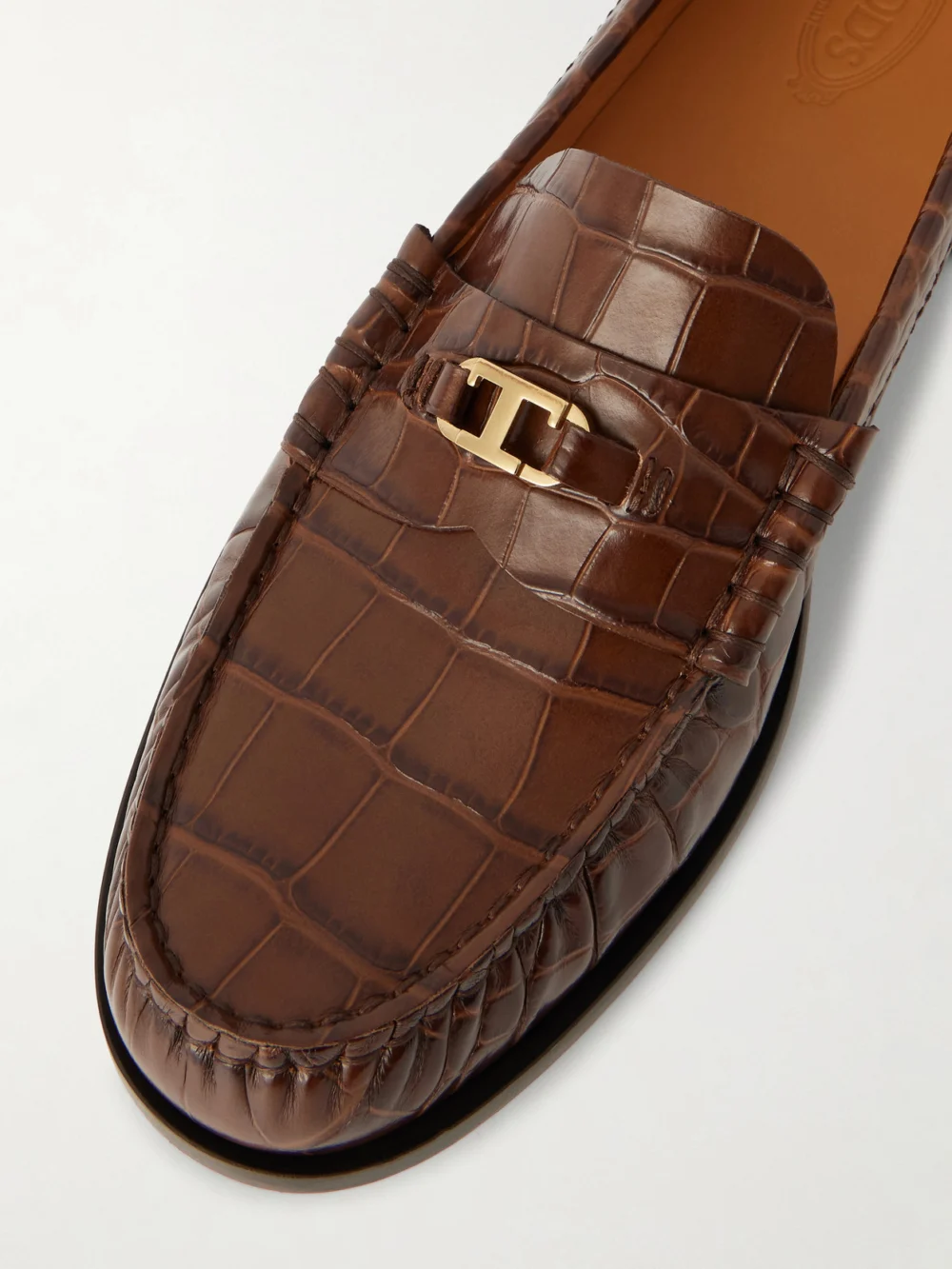 Close-up detail of the Tod's Embellished Croc-effect Leather Loafers