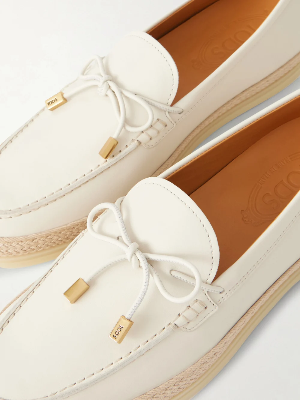 Close-up detail of the Tod's Gomma Raffia-trimmed Bow-detailed Suede Loafers
