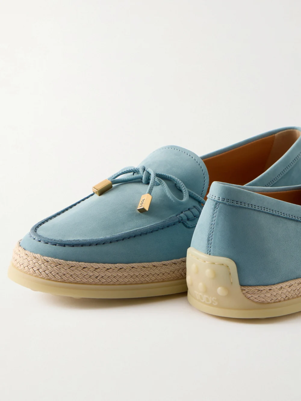 Close-up detail of the Tod's Gomma Raffia-trimmed Bow-detailed Suede Loafers