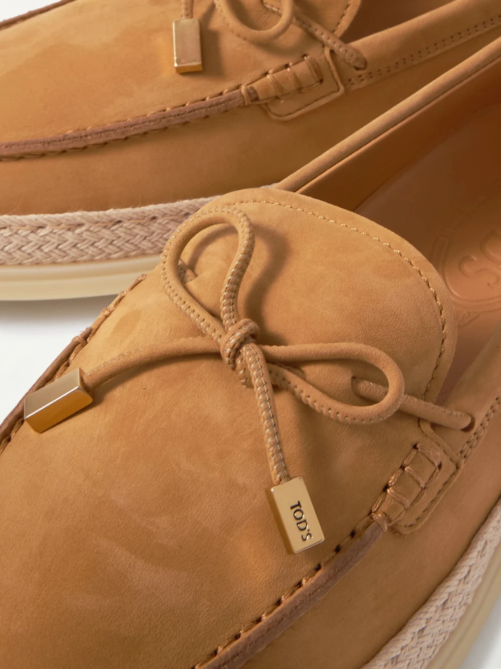 Close-up detail of the Tod's Gomma Raffia-trimmed Bow-detailed Suede Loafers
