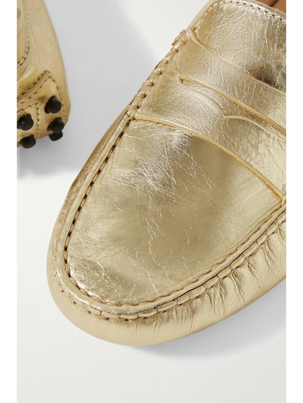 Close-up detail of the Tod's Gommino Metallic Textured-leather Loafers