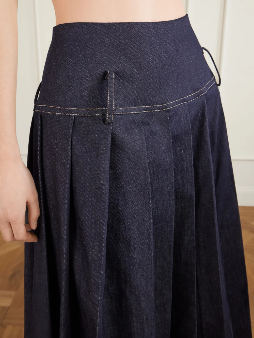 Close-up detail of the Tolu Coker Pleated Denim Maxi Skirt