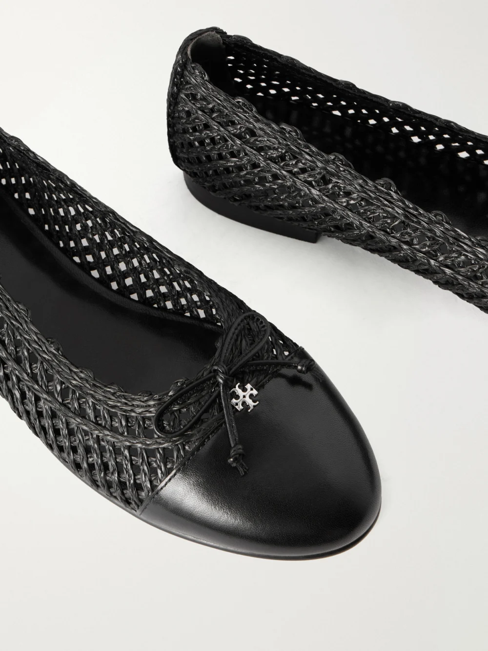 Close-up detail of the Tory Burch Bow-detail Leather-trimmed Raffia Ballet Flats