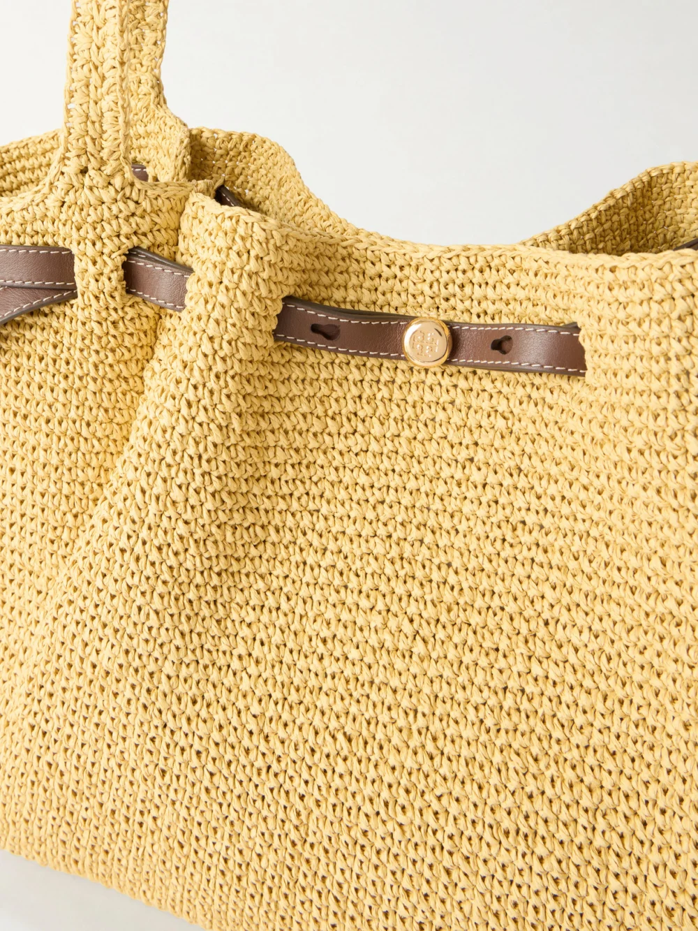 Close-up detail of the Tory Burch Romy Leather-trimmed Straw Tote