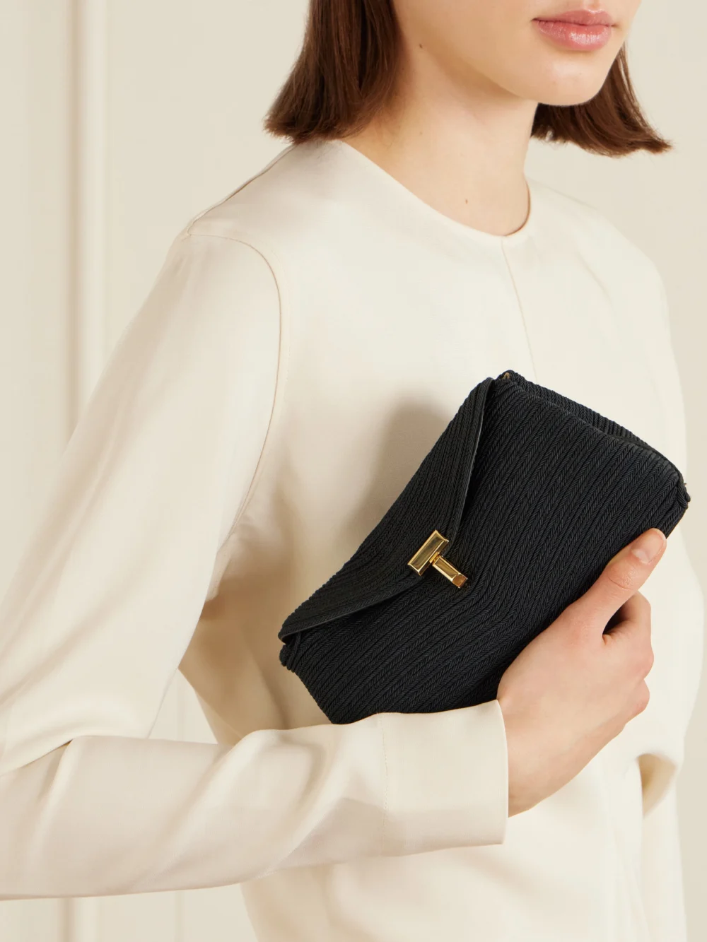 Totême Mini T-lock Leather-trimmed Woven Clutch, styled view
