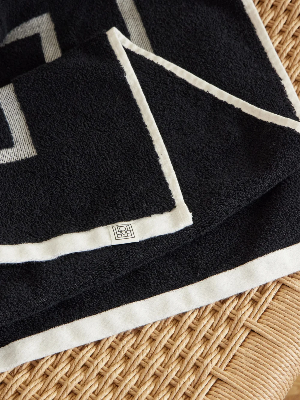 Close-up detail of the Totême Monogram Jacquard Cotton-terry Beach Towel