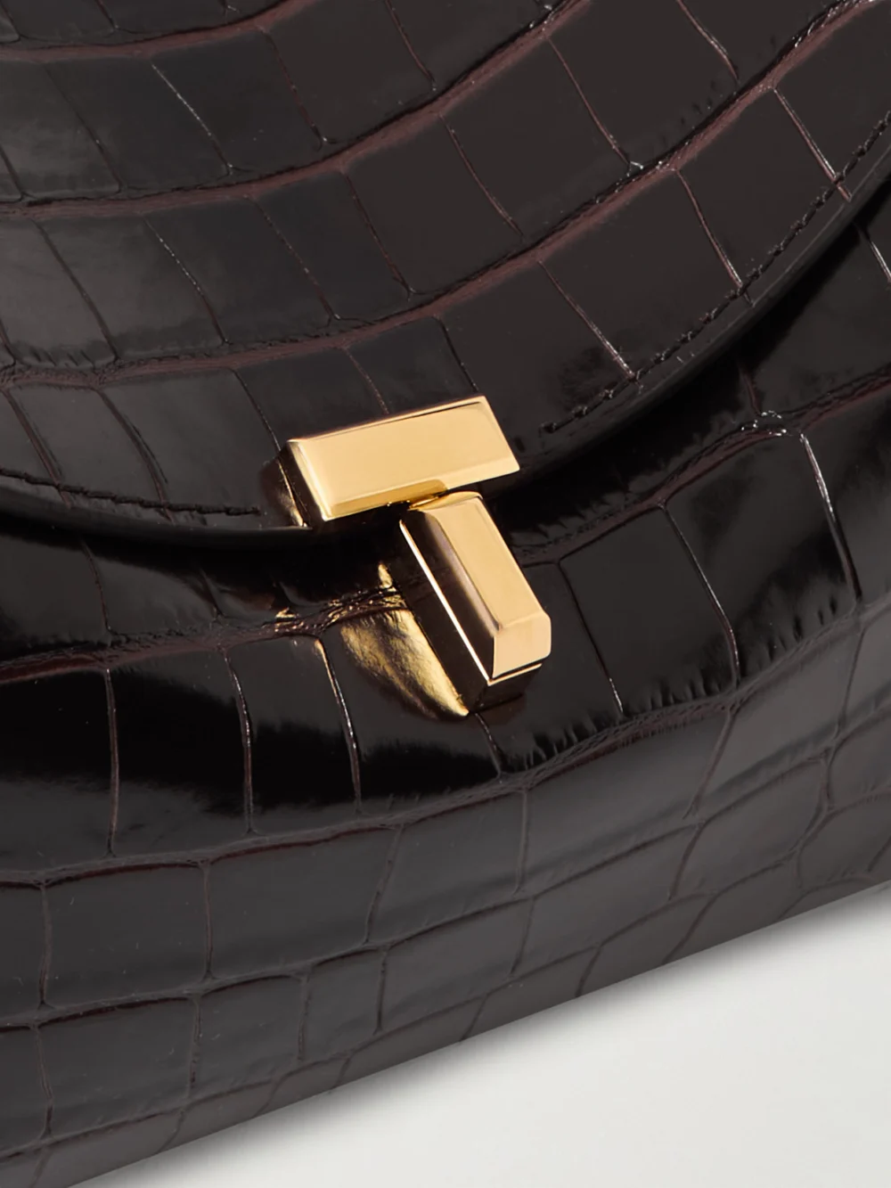 Close-up detail of the Totême T-lock Croc-effect Leather Clutch