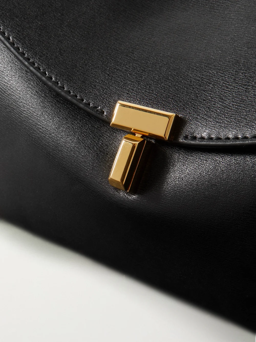 Close-up detail of the Totême T-lock Leather Clutch