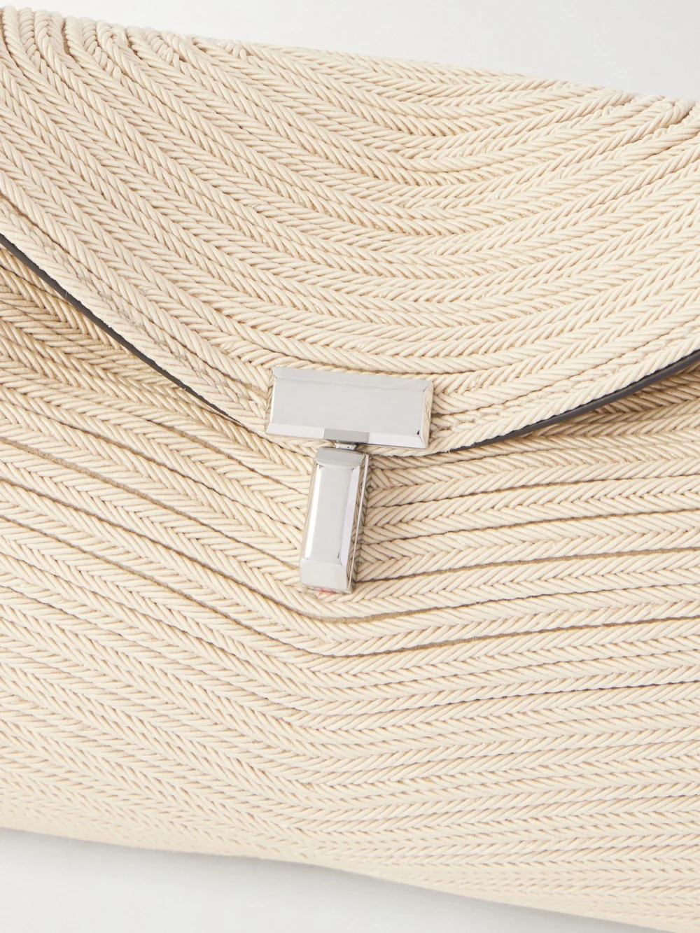Close-up detail of the Totême T-lock Mini Woven Clutch