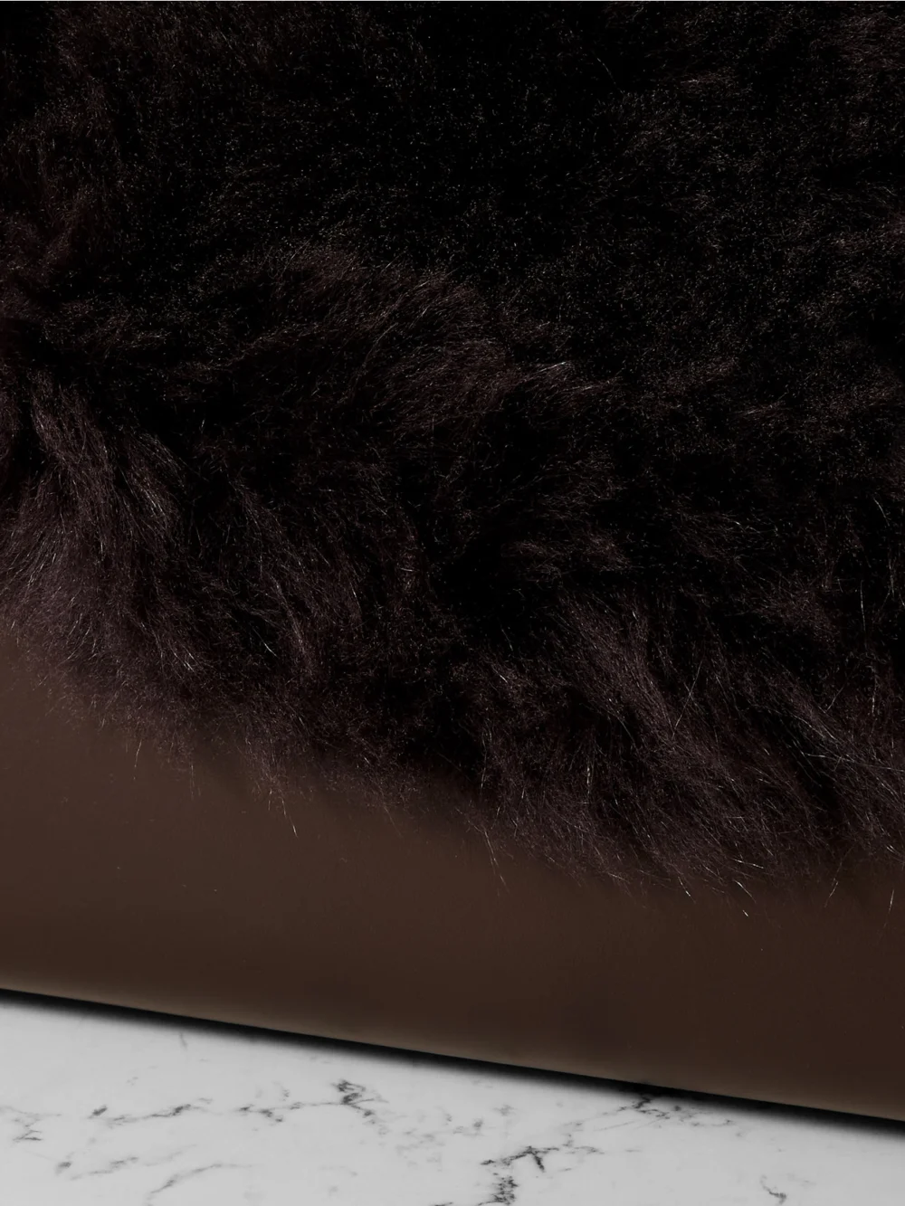 Close-up detail of the Totême T-lock Shearling Shoulder Bag