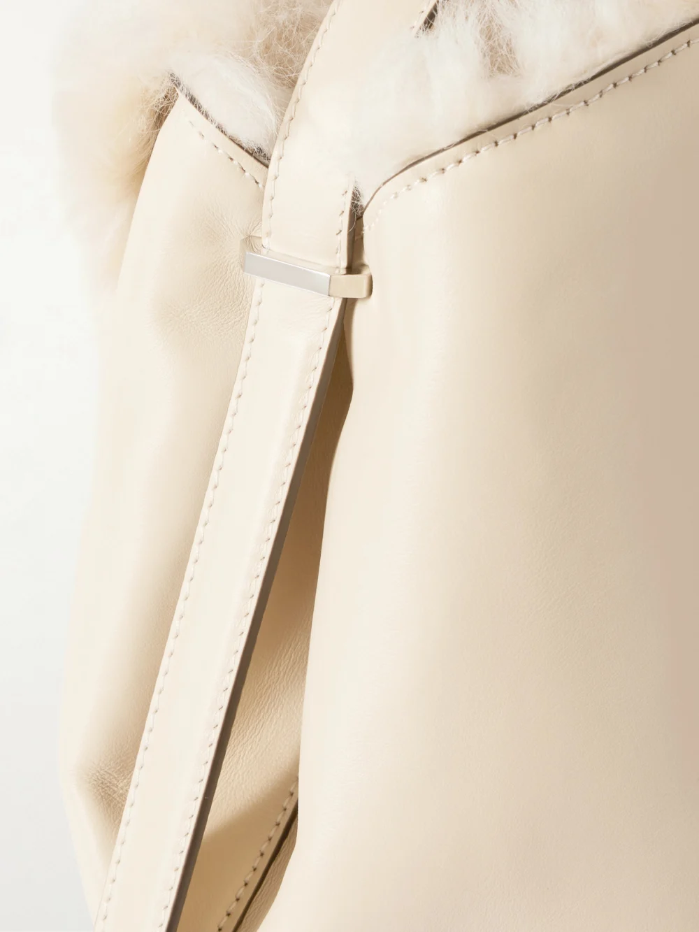 Close-up detail of the Totême T-lock Shearling Shoulder Bag