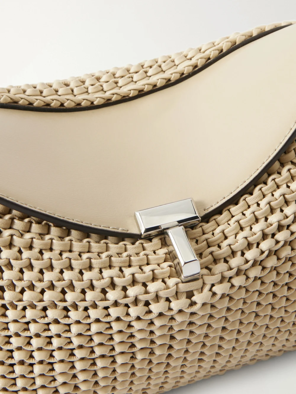 Close-up detail of the Totême T-lock Woven Leather Clutch
