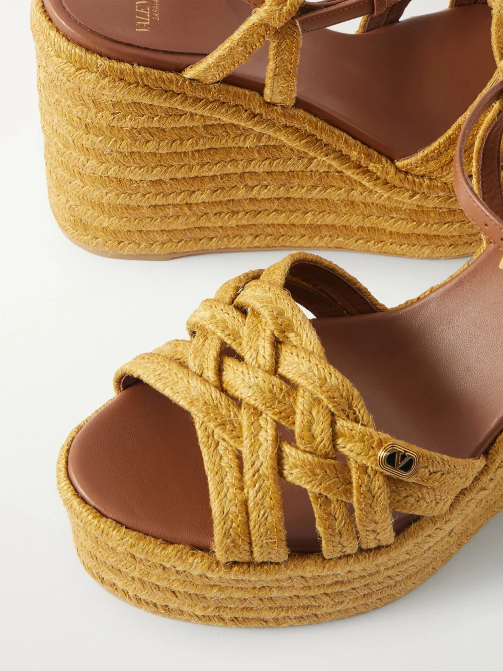 Close-up detail of the Valentino Garavani 120 Leather-trimmed Raffia Wedge Sandals