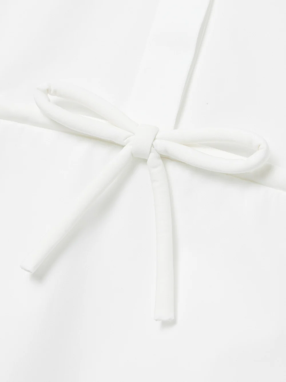 Close-up detail of the Valentino Garavani Bow-detailed Pleated Cotton-poplin Mini Shirt Dress