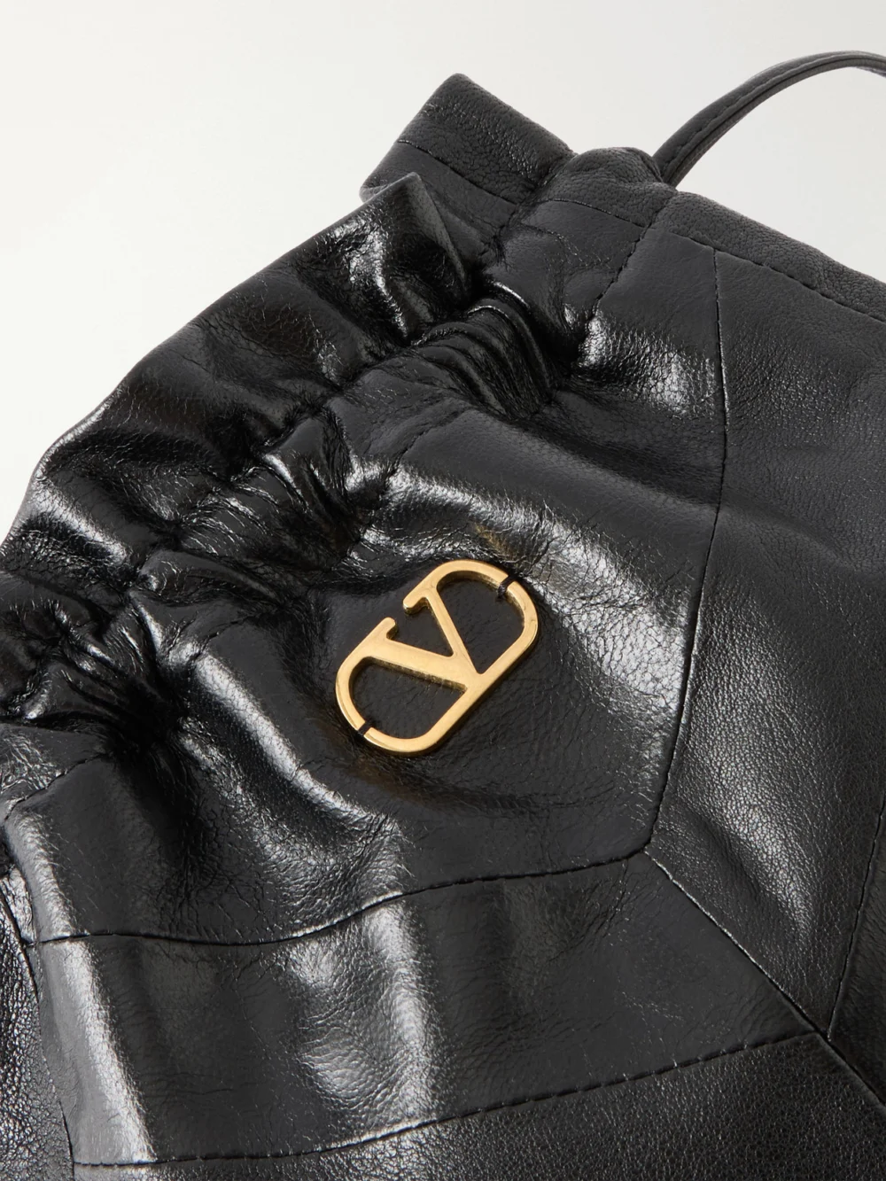 Close-up detail of the Valentino Garavani Buckette Logo-embellished Drawstring Leather Shoulder Bag