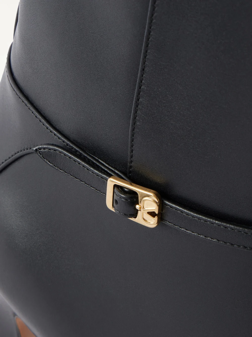 Close-up detail of the Valentino Garavani Pattie 85 Buckle-embellished Leather Knee Boots
