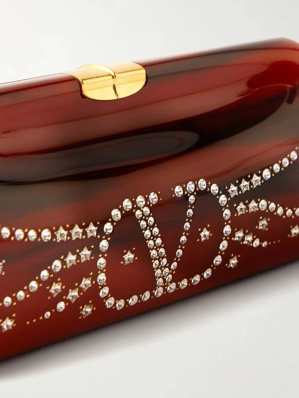 Close-up detail of the Valentino Garavani Pince Vlogo-embellished Resin Clutch