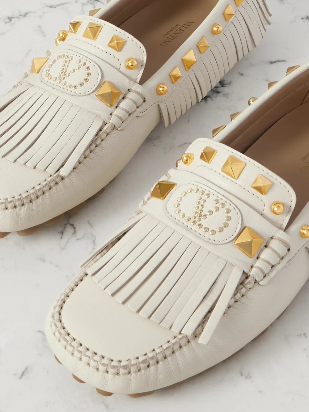 Close-up detail of the Valentino Garavani Plaster Caster Driver Fringed Studded Textured-leather Loafers