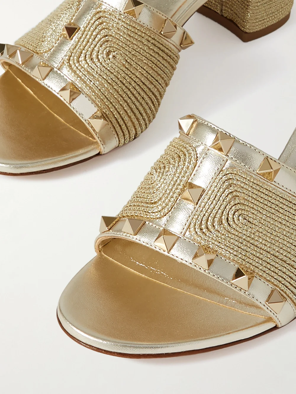 Close-up detail of the Valentino Garavani Rockstud 60 Embellished Raffia-trimmed Metallic Leather Sandals