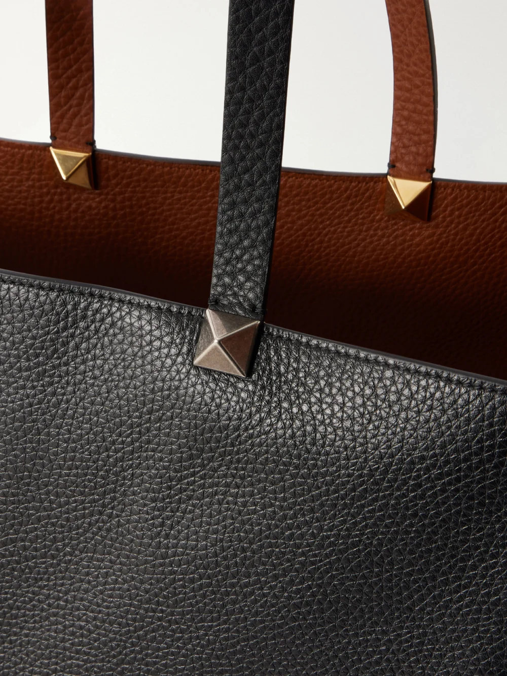 Close-up detail of the Valentino Garavani Rockstud Double Reversible Studded Textured-leather Tote Bag