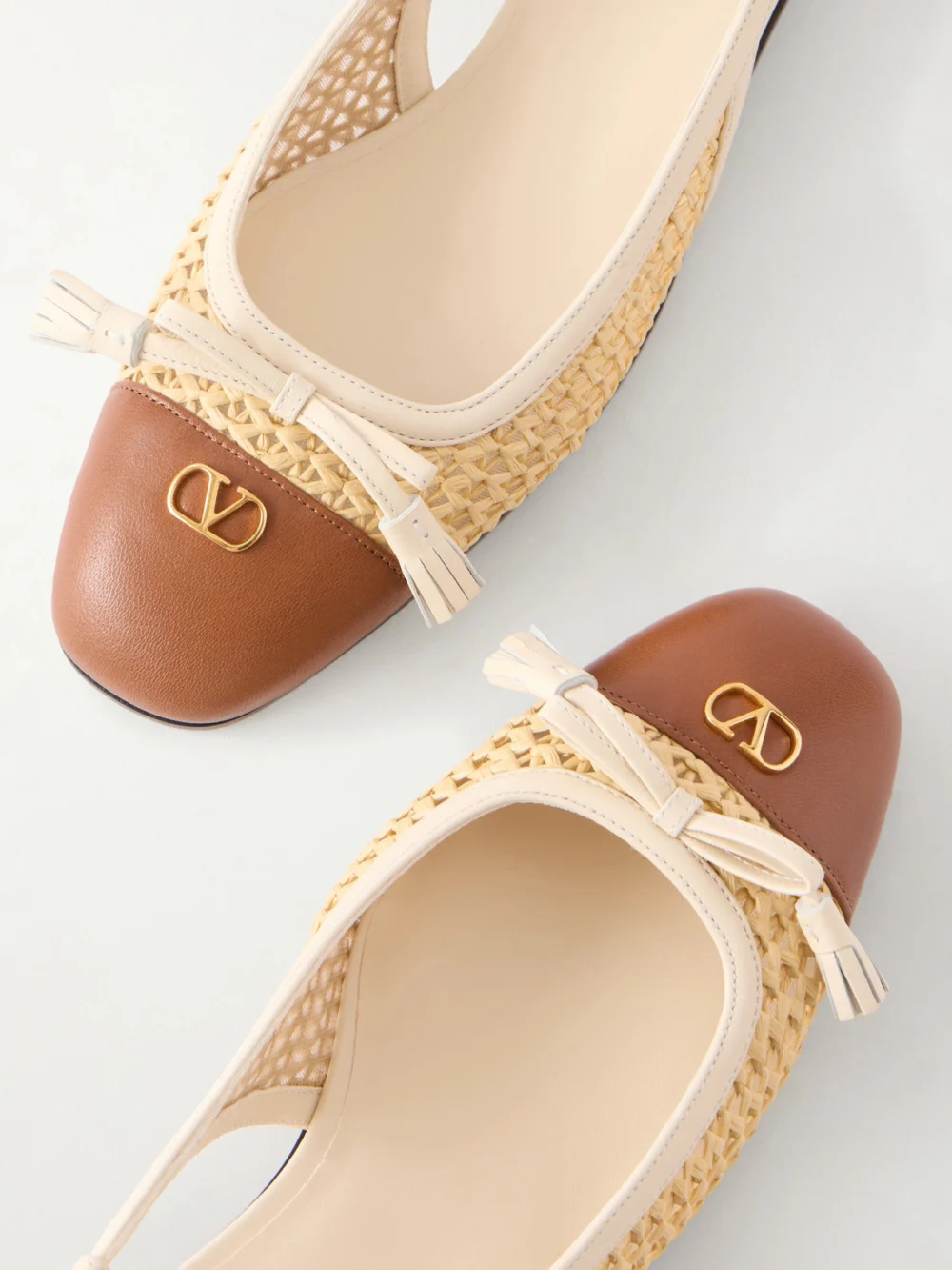 Close-up detail of the Valentino Garavani Valet Du Roi 25 Tasseled Leather-trimmed and Raffia Slingback Ballet Flats