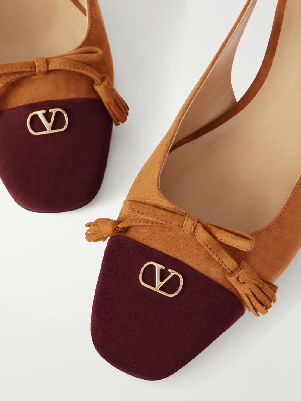 Close-up detail of the Valentino Garavani Valet Du Roi 60 Tasseled Two-tone Suede Slingback Pumps