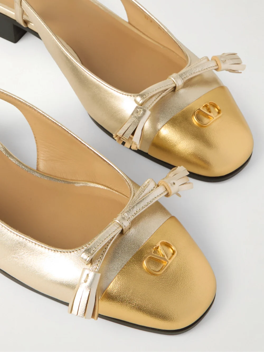 Close-up detail of the Valentino Garavani Valet Du Roi Tasseled Metallic Leather Slingback Pumps