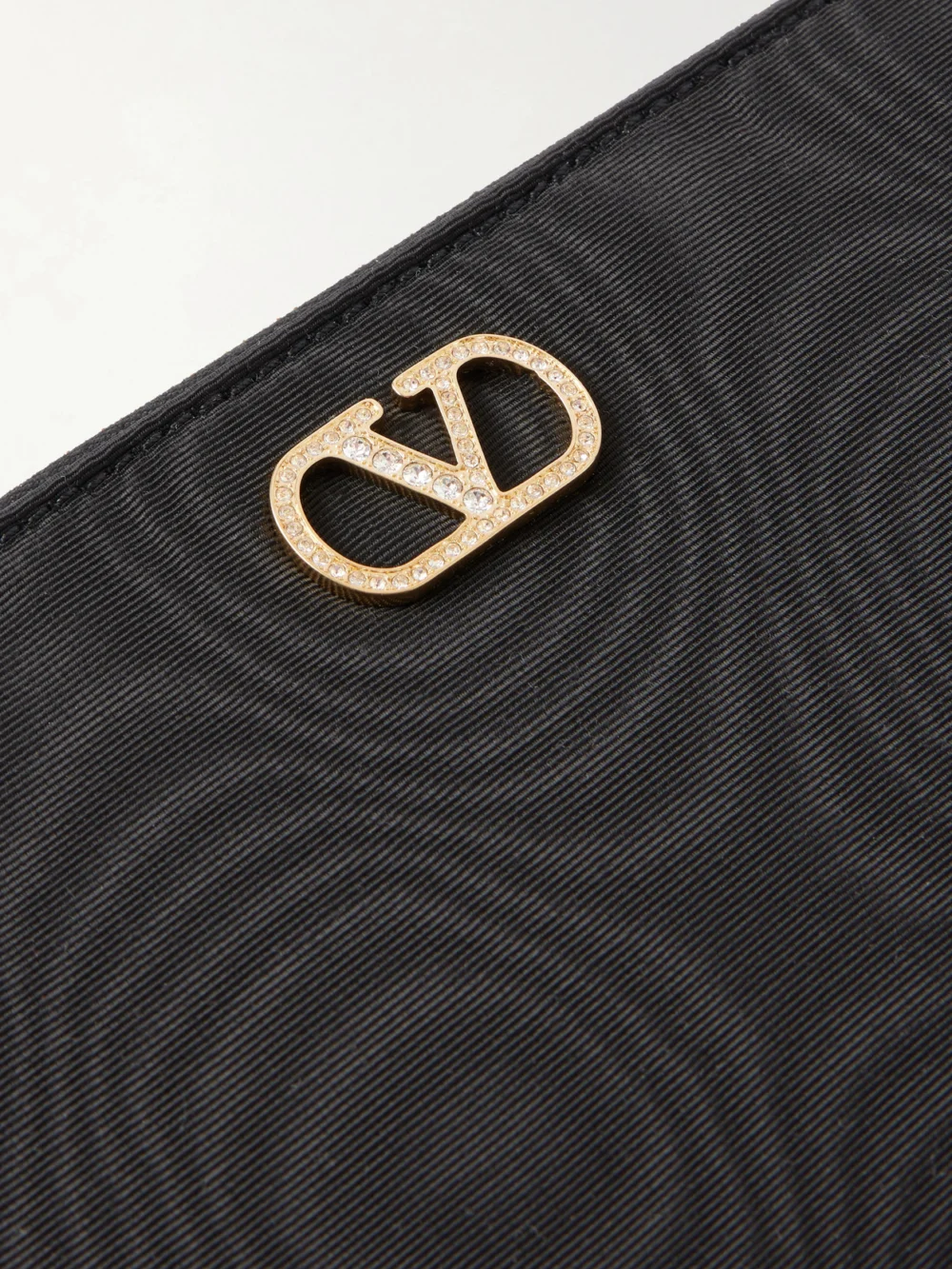 Close-up detail of the Valentino Garavani Vlogo Embellished Moire Clutch